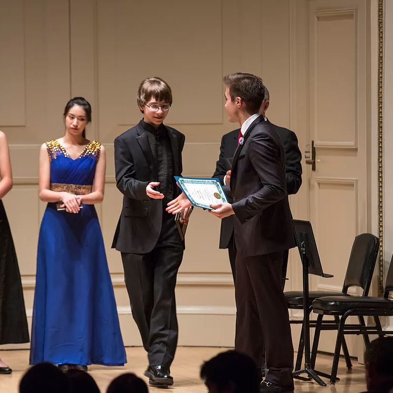 Andrew Bailey accepts an award certificate in an ornate hall.